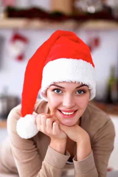 Mujer joven sonriente en la cocina, aislada en el fondo de Navidad —  Fotos de Stock