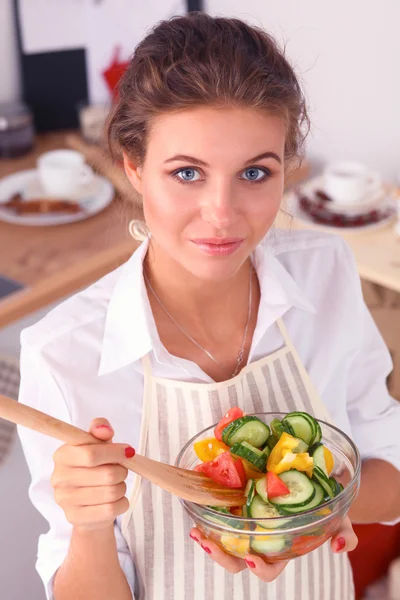 Jovem mulher comendo salada fresca na cozinha moderna — Fotografia de Stock