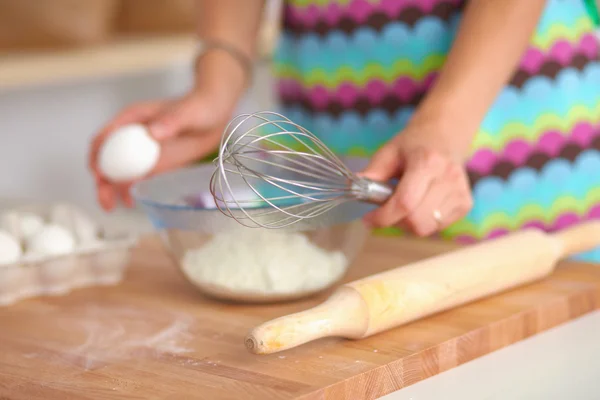 Jeune femme souriante dans la cuisine, isolée sur le fond — Photo