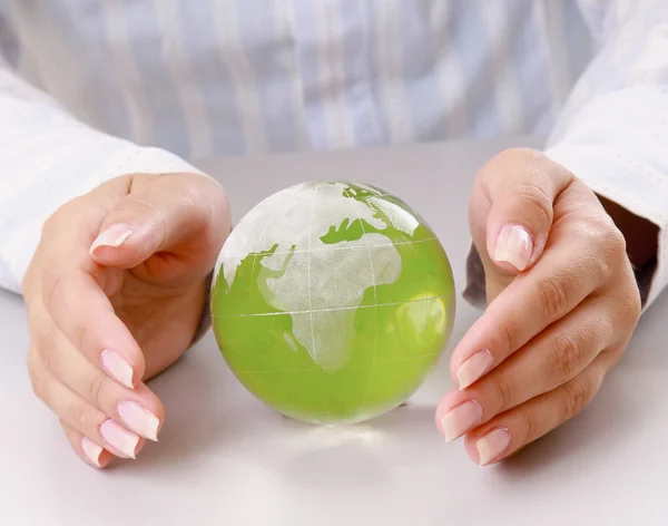 Manos sosteniendo una tierra verde —  Fotos de Stock