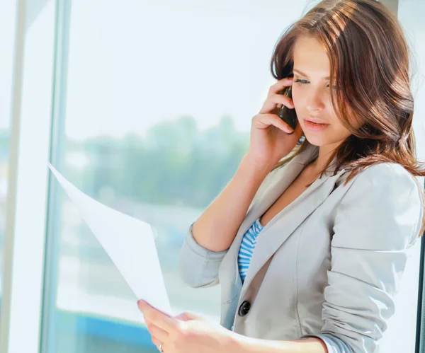 Genç işkadını office koridor üzerinde cep telefonu konuşurken portresi.