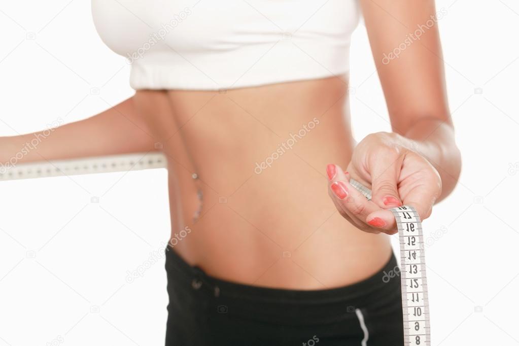 A young woman measuring her waist isolated on white background