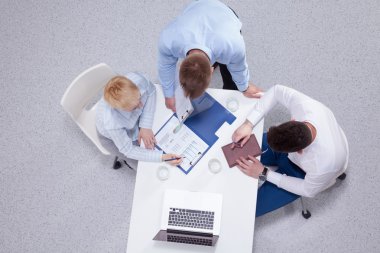 İş adamları iş toplantısında, ofiste oturup tartışıyorlar.