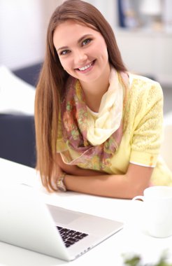 Elinde evrakları olan kadın masanın üstünde oturuyor.