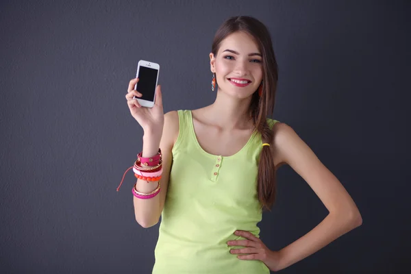 Güzel genç kadın holdiing cep telefonu, gri izole — Stok fotoğraf