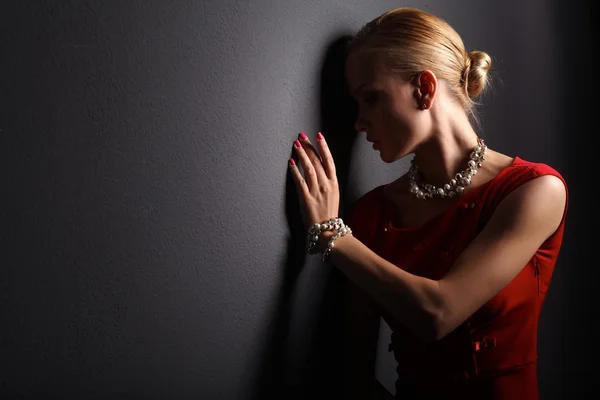 Portrait of young woman on red dress, isolated black background — Stock Photo, Image