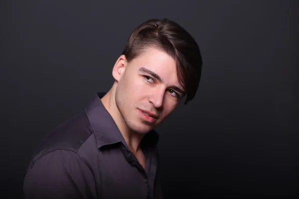 Porträt eines hübschen jungen Mannes auf schwarzem Hintergrund — Stockfoto