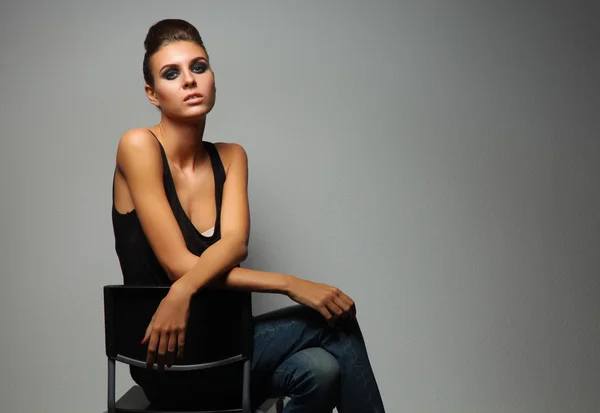 Beautiful woman  sitting  a chair, isolated on gray background Stock Image