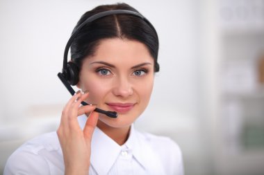 Güzel işkadını masasına kulaklık ve dizüstü çalışan portresi