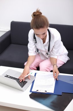 Kanepede oturan genç bir doktorun portresi.