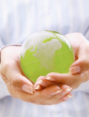 Beyaz arka plan üzerinde izole yeşil bir dünya holding eller