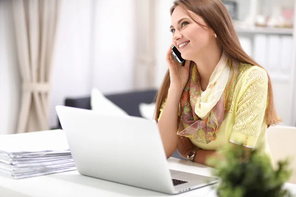 cep telefonu ve dizüstü evde kullanan kadın