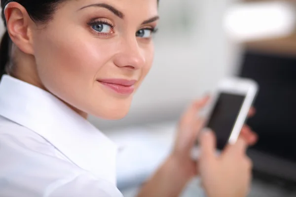 Femme d'affaires envoyer un message avec smartphone assis dans le bureau — Photo