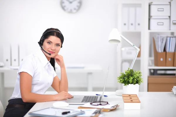 Portrait of beautiful businesswoman working at her desk with headset and laptop — Stock Photo, Image