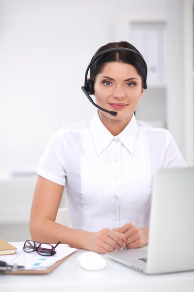 Retrato de mulher de negócios bonita trabalhando em sua mesa com fone de ouvido e laptop — Fotografia de Stock