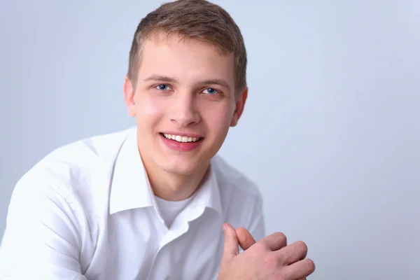 Портрет молодого человека, улыбающегося на сером фоне — стоковое фото