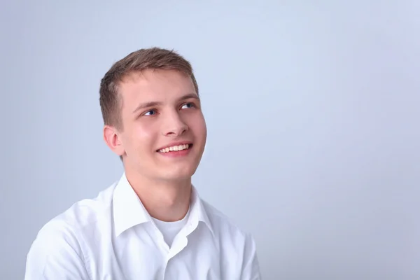 Portret van de jonge man die lacht geïsoleerd op grijze achtergrond — Stockfoto