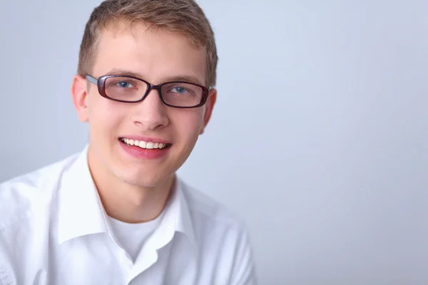 Porträt eines jungen Mannes, der isoliert auf grauem Hintergrund lächelt — Stockfoto