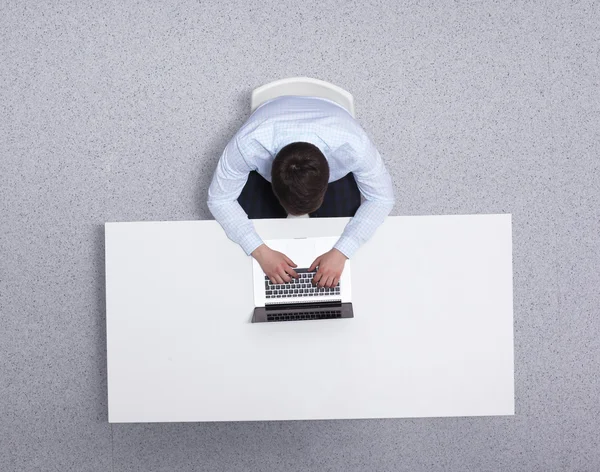 genç adam dizüstü bilgisayarda çalışan Resepsiyon ofisinde oturuyor