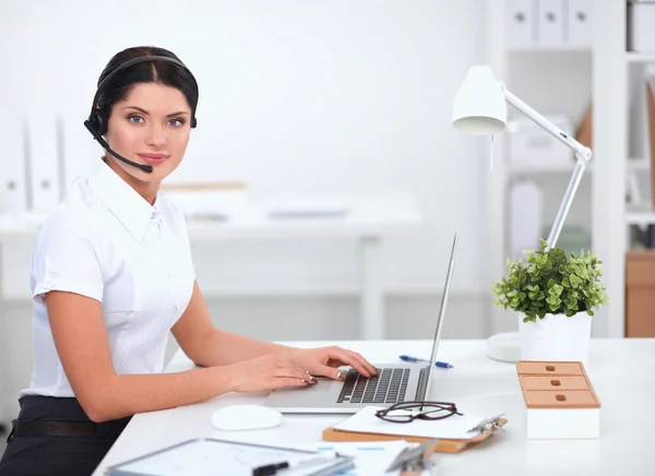 Portrait of beautiful businesswoman working at her desk with headset and laptop — Stock Photo, Image