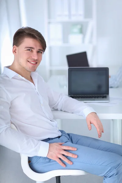 Joven hombre de negocios trabajando en la oficina, sentado en el escritorio — Foto de Stock