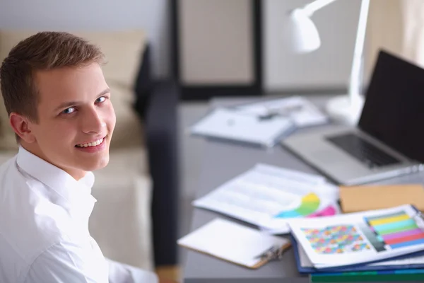 Smiling businessman with folder sitting in the office — Stock Photo, Image