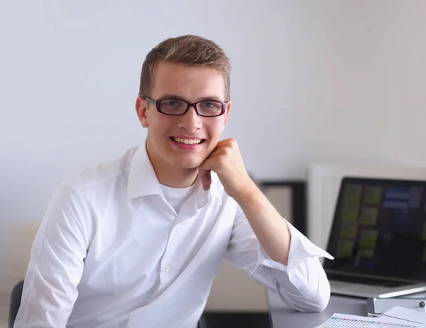 Smiling businessman with folder sitting in the office — Stock Photo, Image