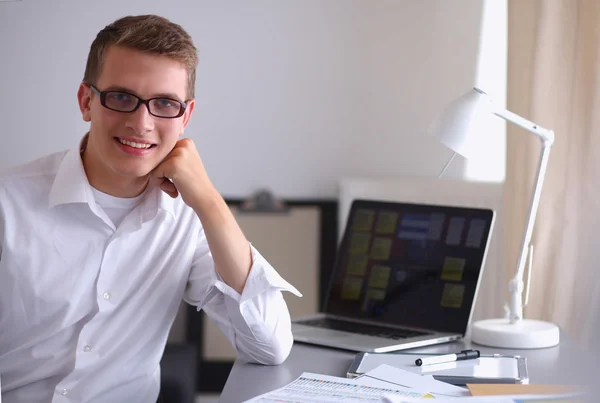 Smiling businessman with folder sitting in the office — Stock Photo, Image