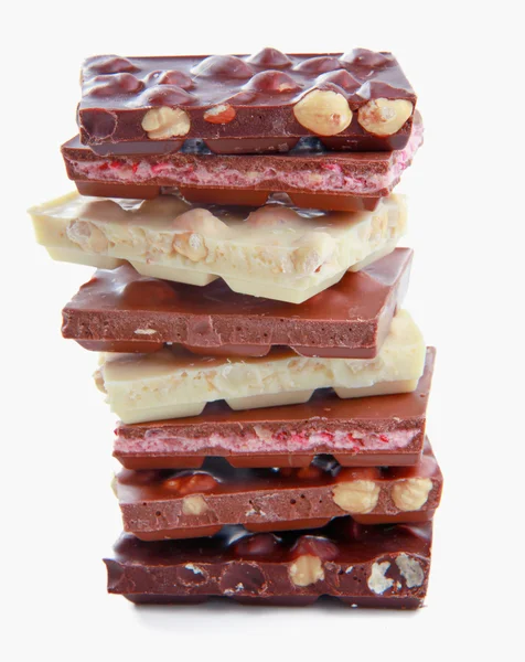 Stapel von Schokoladenstücken auf weißem Hintergrund — Stockfoto