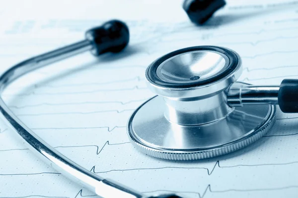 Een blauwe stethoscoop op een cardiogram — Stockfoto
