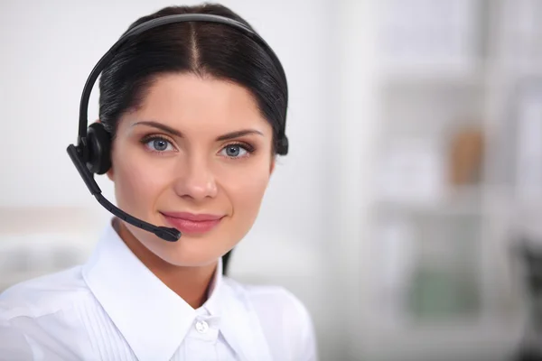 Portrait of beautiful businesswoman working at her desk with headset and laptop — Stock Photo, Image