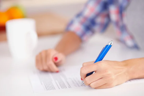 Jonge vrouw schrijft iets in haar notitieblok. — Stockfoto