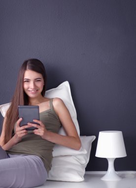 bir yastık ve uçak tablo ile katta oturan güzel esmer kadın