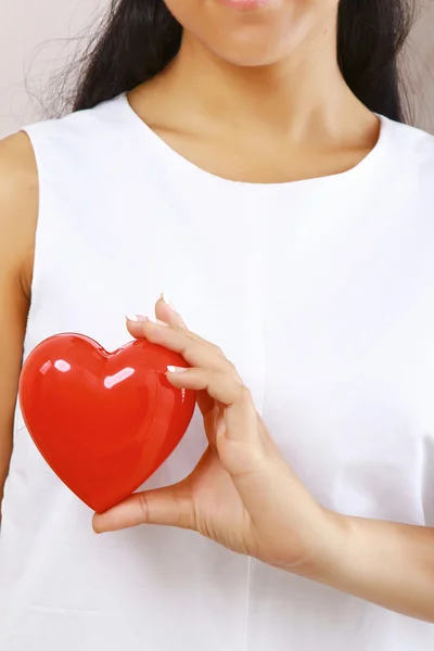 Vrouwelijke handen met rood hart — Stockfoto