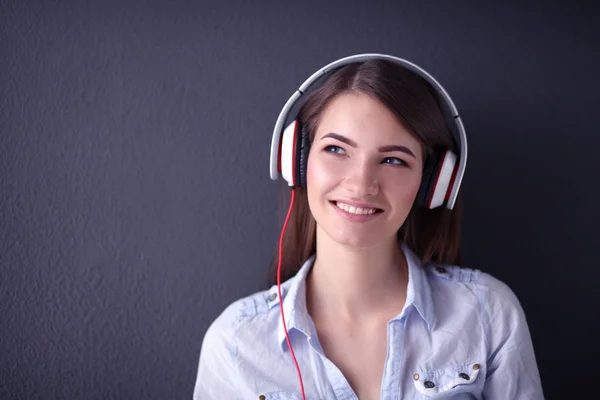 Smiling girl with headphones sitting on the floor — Stock Photo, Image