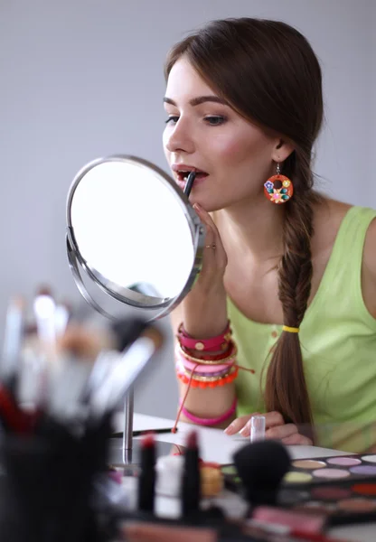 Młoda piękna kobieta robi makijaż w pobliżu lustra — Zdjęcie stockowe