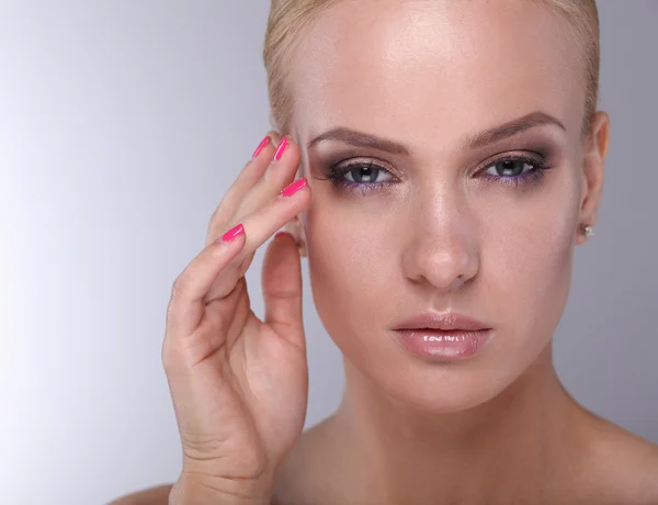 Jonge vrouw aanraken haar gezicht geïsoleerd op witte achtergrond — Stockfoto