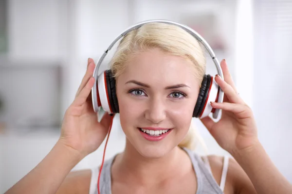 Joven hermosa mujer en casa sentada en el sofá y escuchando música —  Fotos de Stock