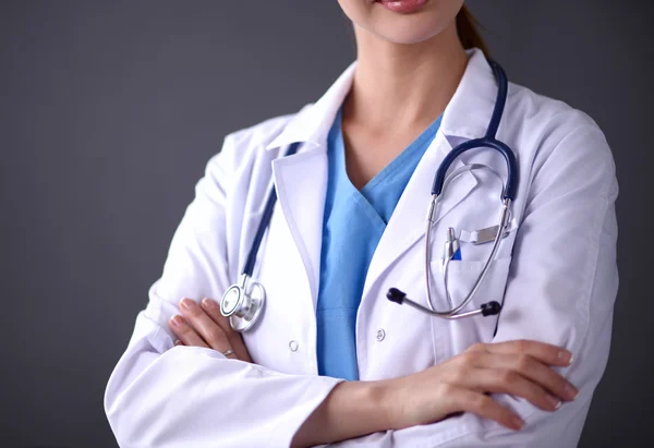 Doctor woman with stethoscope standing near grey wall — Stock Photo, Image