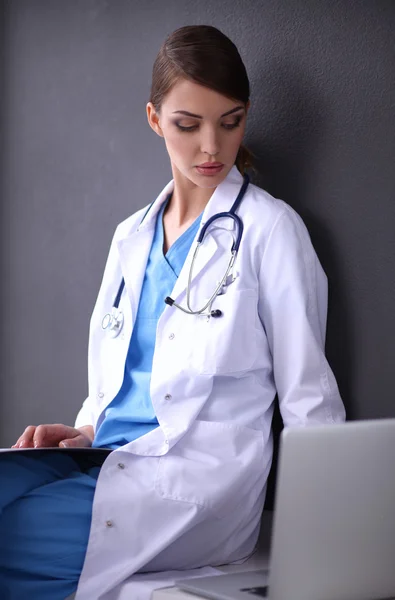 Médico femenino trabajando aislado sobre fondo gris — Foto de Stock