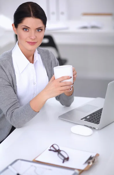 Attraktive Geschäftsfrau sitzt auf Schreibtisch im Büro — Stockfoto