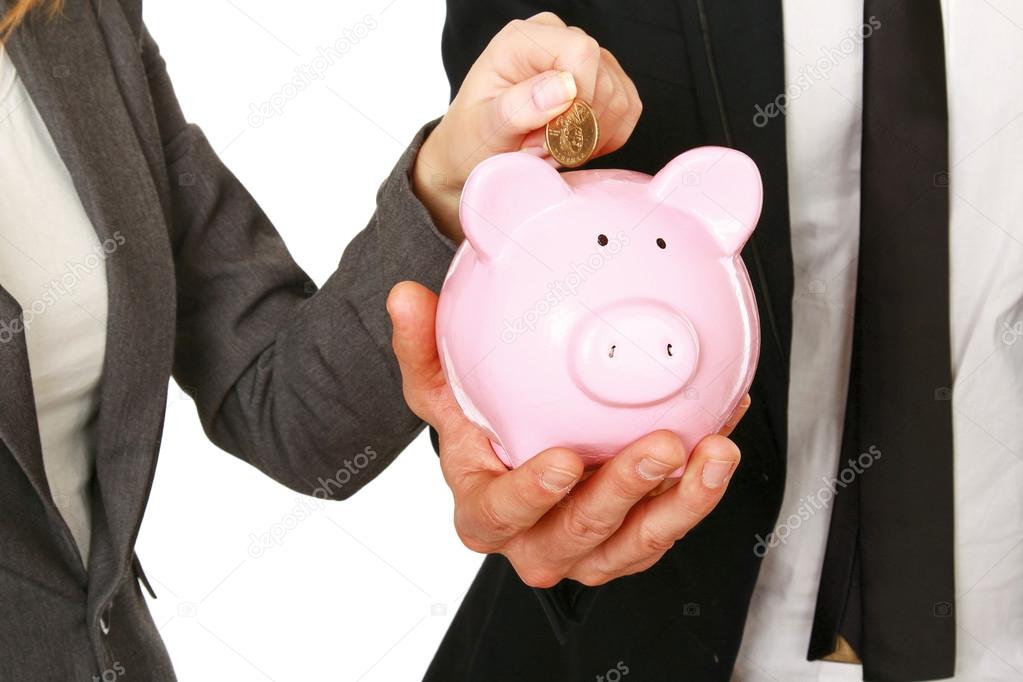 A businesswoman and man putting a coin into a piggy bank isolated on white background