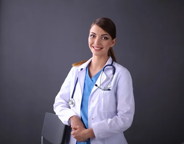सुंदर महिला डॉक्टर स्टूल के पास खड़े अलग ग्रे पृष्ठभूमि — स्टॉक फ़ोटो, इमेज