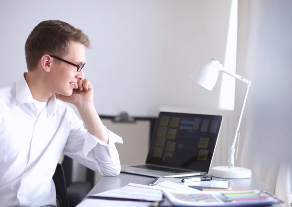 Young businessman working in office, sitting at desk — Stock Photo, Image