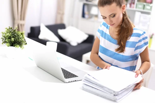 Femme avec des documents assis sur le bureau et ordinateur portable — Photo