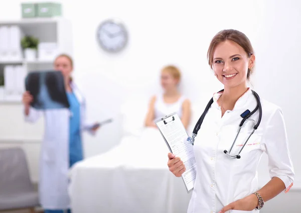 Nainen lääkäri seisoo kansio sairaalassa — kuvapankkivalokuva