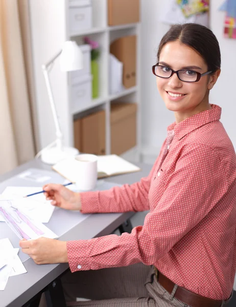 Jonge aantrekkelijke vrouwelijke mode-ontwerper werken op kantoor bureau, tekenen terwijl het praten op mobiele — Stockfoto