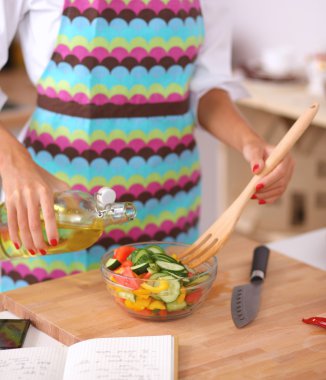 Gülümseyen genç kadın taze salata hazırlıyor.
