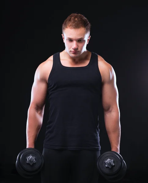 Handsome muscular man working out with dumbbells — Stock Photo, Image