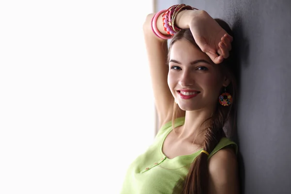 Young woman standing near dark wall — Stock Photo, Image